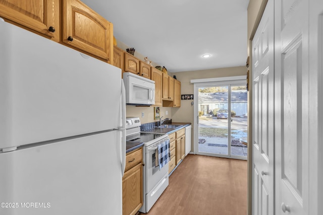 kitchen featuring sink, white appliances, and light wood-type flooring