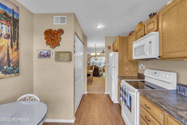 kitchen with light brown cabinetry, white appliances, light wood-type flooring, and an inviting chandelier