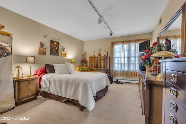 carpeted bedroom featuring a baseboard heating unit and track lighting