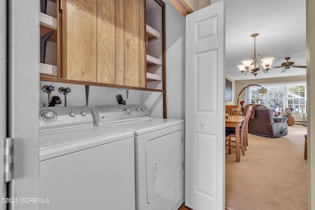 laundry room featuring a baseboard heating unit, light colored carpet, independent washer and dryer, cabinets, and ceiling fan with notable chandelier