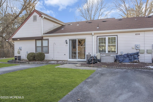 rear view of house featuring a yard