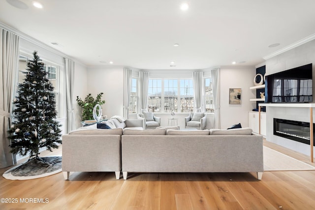 living room with plenty of natural light, light hardwood / wood-style floors, and a tile fireplace