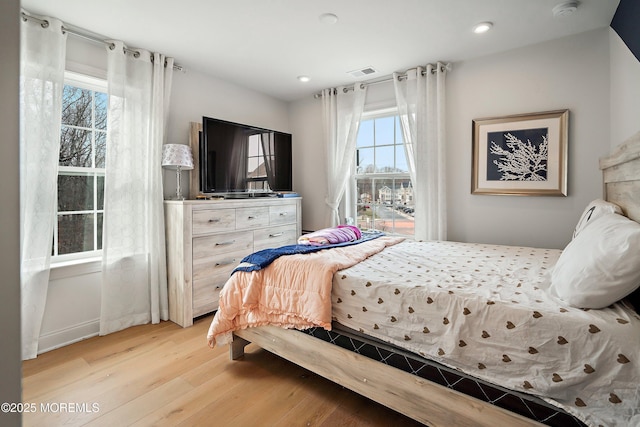 bedroom featuring multiple windows and light wood-type flooring