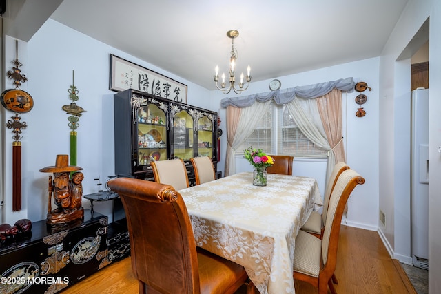 dining room with hardwood / wood-style flooring and a notable chandelier