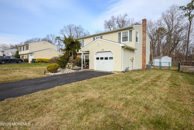 view of front property with central AC unit, a front lawn, and a garage