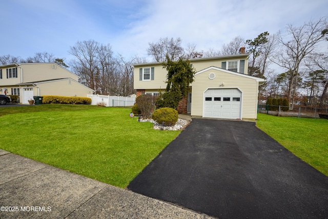 view of front of house featuring a front yard, fence, and aphalt driveway