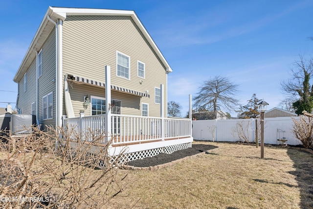 rear view of property with a lawn, fence private yard, and a wooden deck