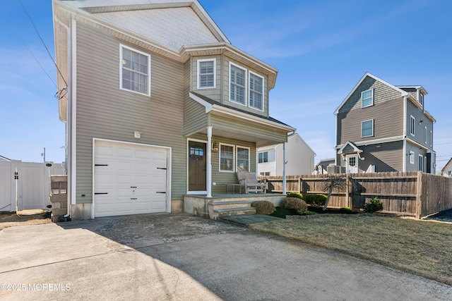 view of front of house featuring a garage, concrete driveway, and fence