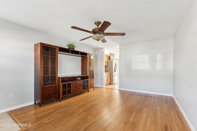 unfurnished living room featuring baseboards, a ceiling fan, and light wood-style floors