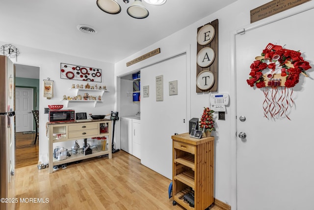 interior space featuring washing machine and dryer and light wood-type flooring