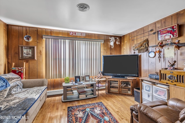 living room featuring wood walls, light hardwood / wood-style floors, and a baseboard radiator