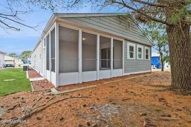 view of side of property with a sunroom and central air condition unit