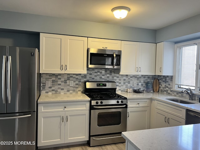 kitchen with sink, white cabinets, and appliances with stainless steel finishes