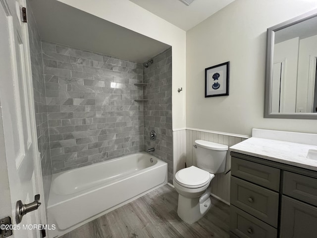 full bathroom featuring toilet, wood-type flooring, vanity, and tiled shower / bath