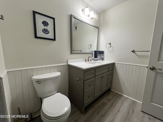 bathroom with hardwood / wood-style floors, vanity, and toilet