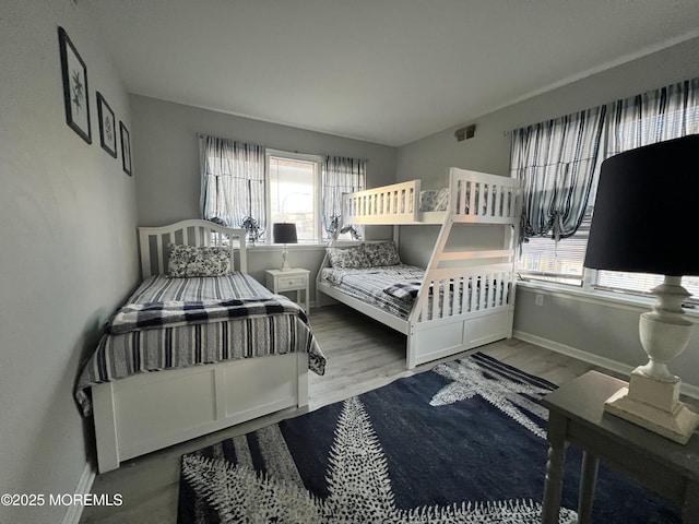 bedroom with multiple windows and hardwood / wood-style flooring