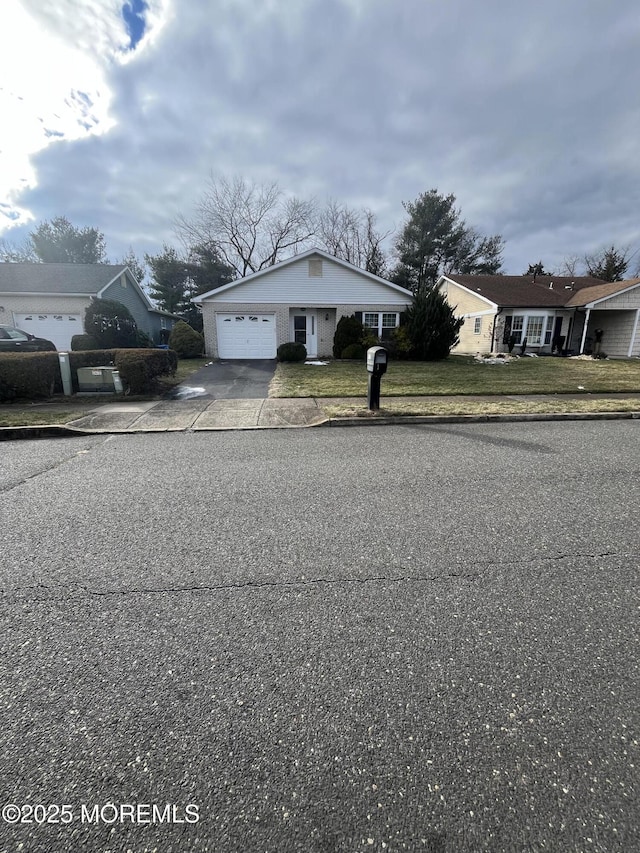 view of front of home with a garage and a front lawn