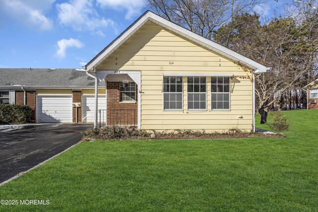 bungalow-style home featuring a front lawn and a garage