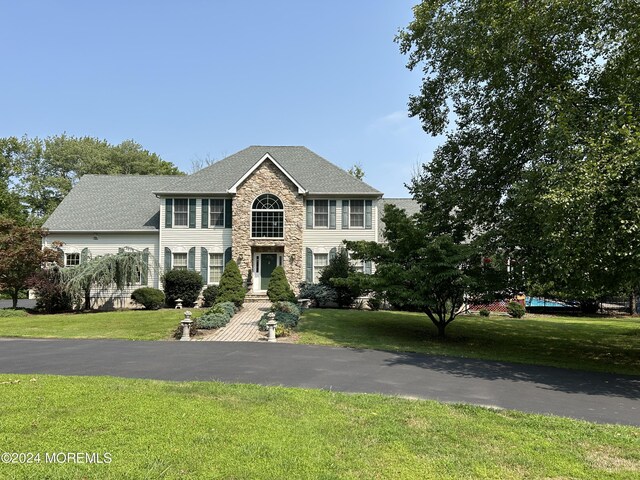 colonial-style house featuring a front yard