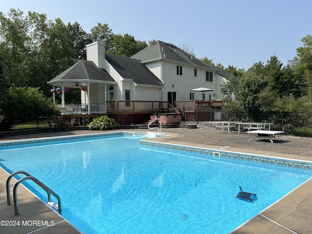 view of swimming pool with a patio, ceiling fan, and a wooden deck