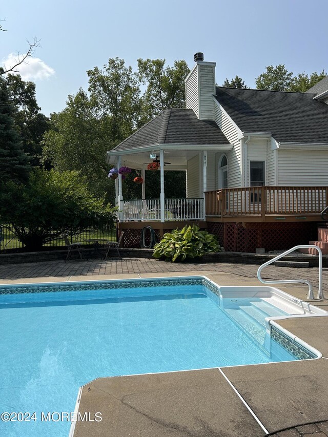 view of pool with a wooden deck and ceiling fan