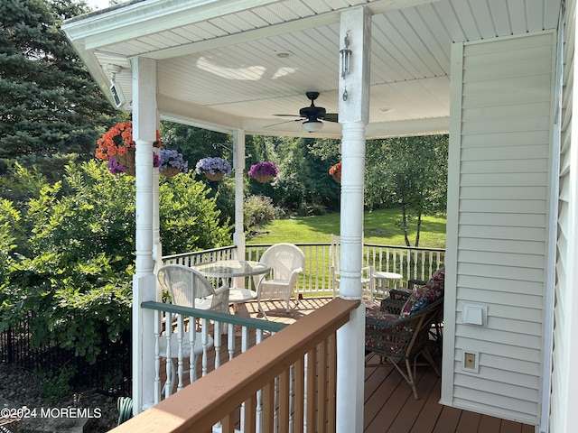 wooden deck with a yard and ceiling fan