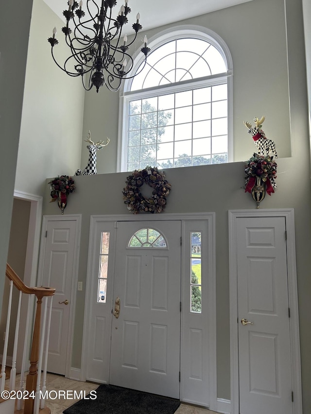 tiled entryway with a chandelier