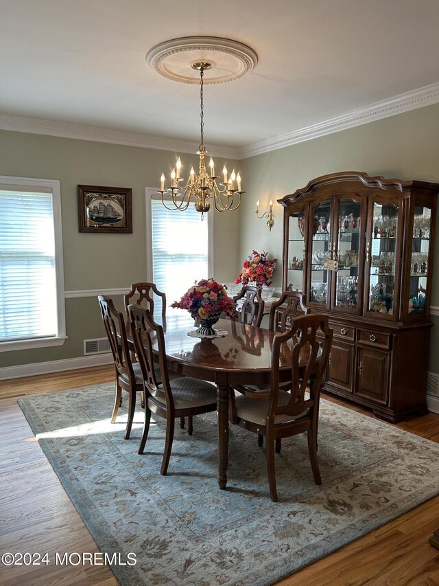 dining room with a chandelier, a healthy amount of sunlight, and light hardwood / wood-style floors