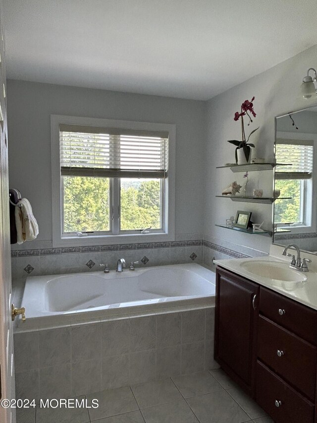 bathroom featuring tile patterned floors, tiled tub, and vanity