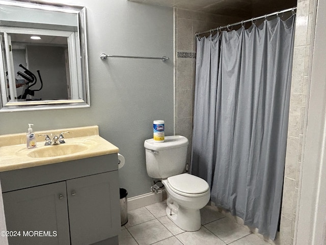 bathroom featuring tile patterned flooring, vanity, toilet, and walk in shower