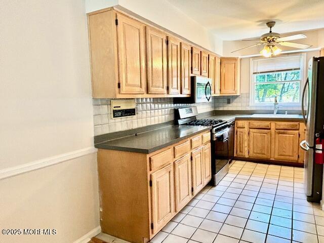 kitchen with sink, ceiling fan, decorative backsplash, light tile patterned flooring, and stainless steel appliances