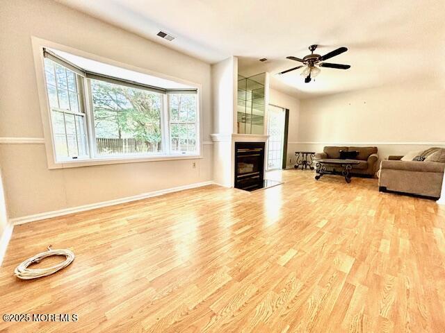 living room featuring a wealth of natural light, ceiling fan, and wood-type flooring