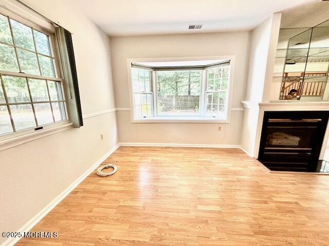 unfurnished living room with light hardwood / wood-style flooring and plenty of natural light