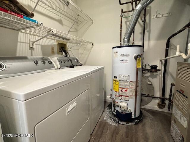 washroom featuring separate washer and dryer, gas water heater, and dark wood-type flooring