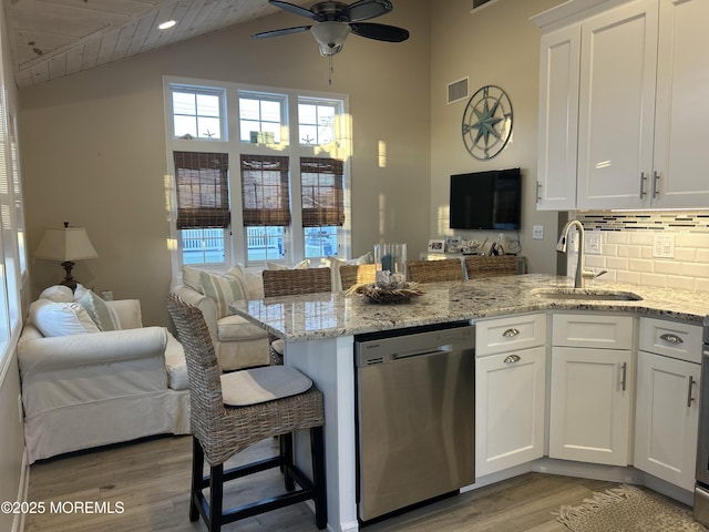 kitchen with sink, white cabinetry, dishwasher, and light stone counters