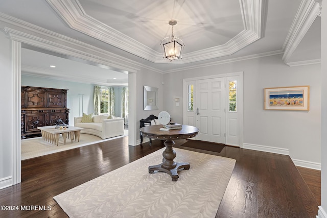 foyer featuring dark hardwood / wood-style flooring, a tray ceiling, and ornamental molding