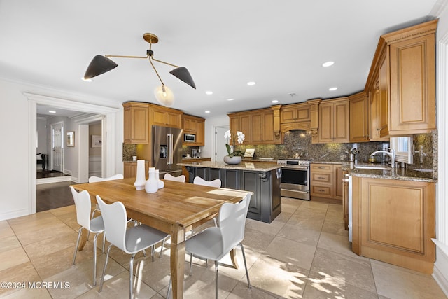 kitchen with a kitchen island, light stone counters, backsplash, and appliances with stainless steel finishes