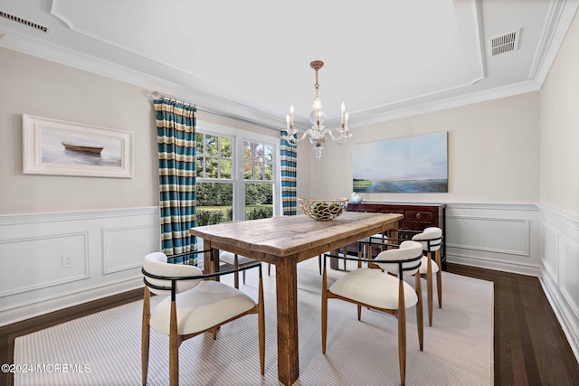 dining space featuring dark hardwood / wood-style flooring, ornamental molding, and an inviting chandelier