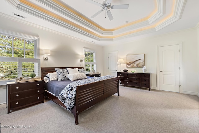 carpeted bedroom with a tray ceiling, ceiling fan, and ornamental molding