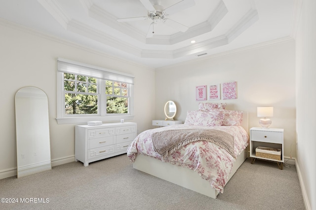 bedroom with ceiling fan, light colored carpet, ornamental molding, and a tray ceiling