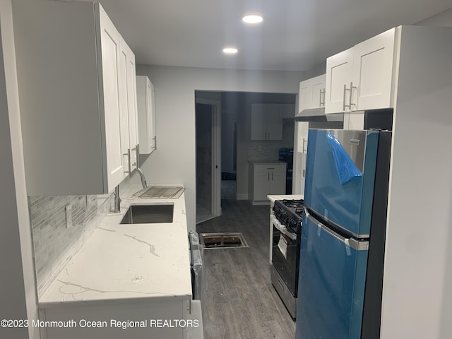 kitchen featuring white cabinetry, sink, stainless steel appliances, tasteful backsplash, and light stone counters