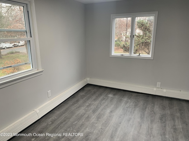 empty room with hardwood / wood-style floors and a baseboard radiator