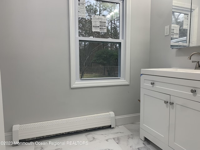 bathroom featuring vanity, baseboard heating, and a healthy amount of sunlight