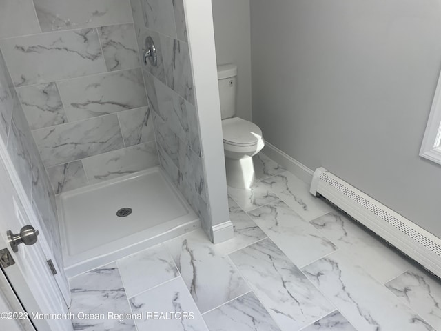 bathroom featuring a tile shower, a baseboard radiator, and toilet