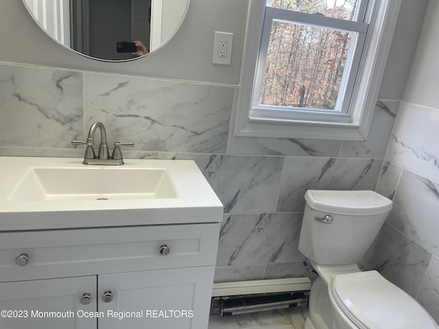 bathroom featuring vanity, toilet, and tile walls