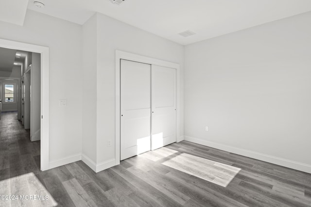 unfurnished bedroom featuring a closet and hardwood / wood-style flooring