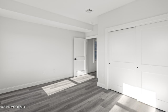 unfurnished bedroom featuring a closet and dark hardwood / wood-style floors