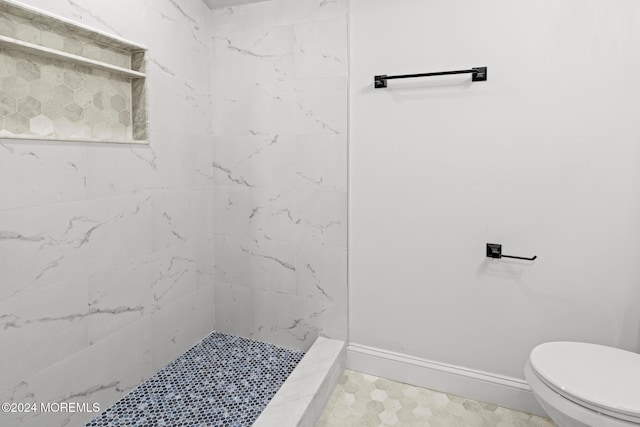 bathroom featuring toilet and tiled shower