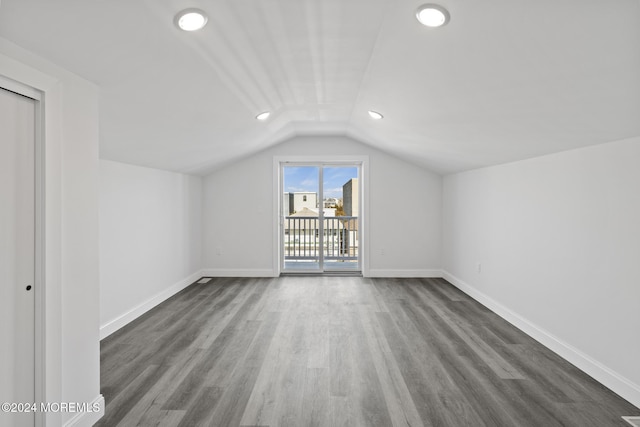 additional living space featuring lofted ceiling and dark wood-type flooring