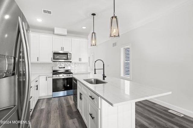 kitchen featuring pendant lighting, stainless steel appliances, an island with sink, white cabinets, and sink